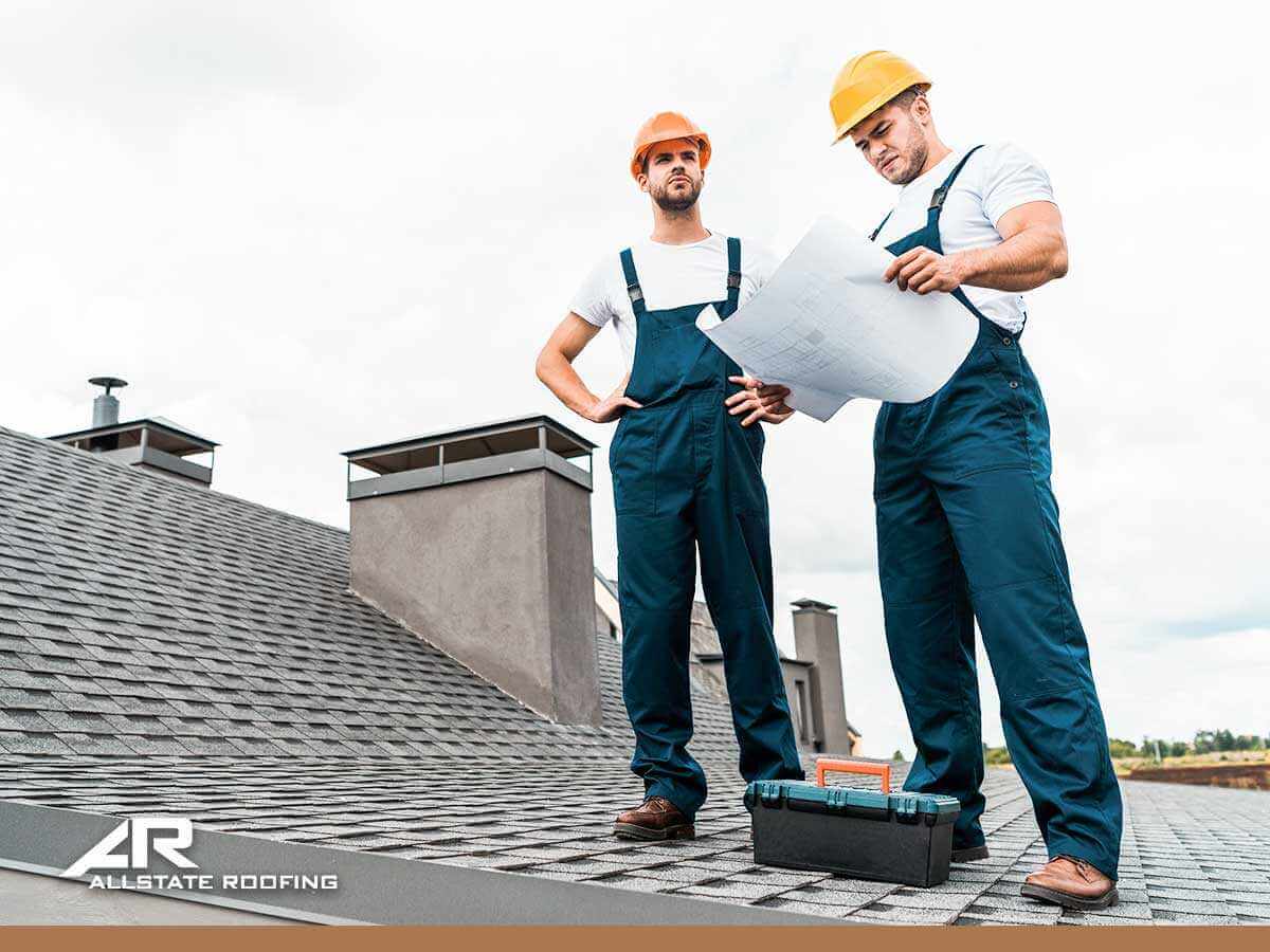 Professional roofers inspecting a roof that might need a repair in Phoenix, AZ