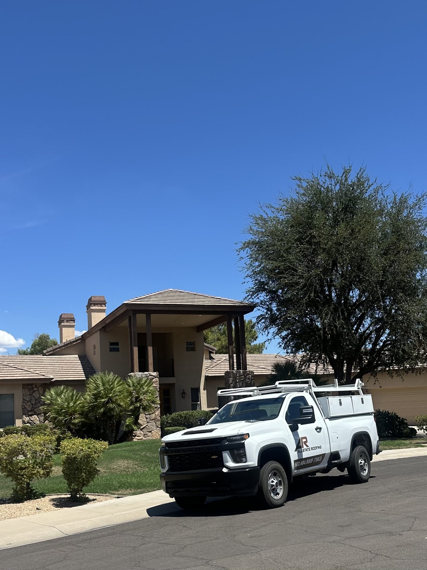 Allstate Roofing service truck in front of an Arizona residence