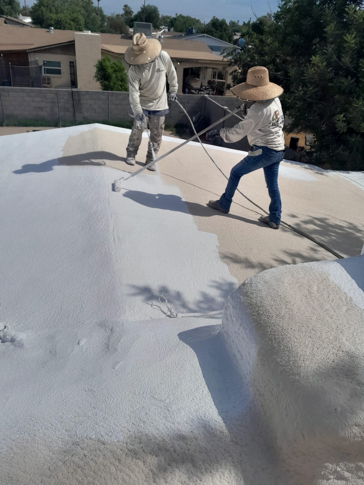 Allstate Roofing crew applying elastomeric roof coating