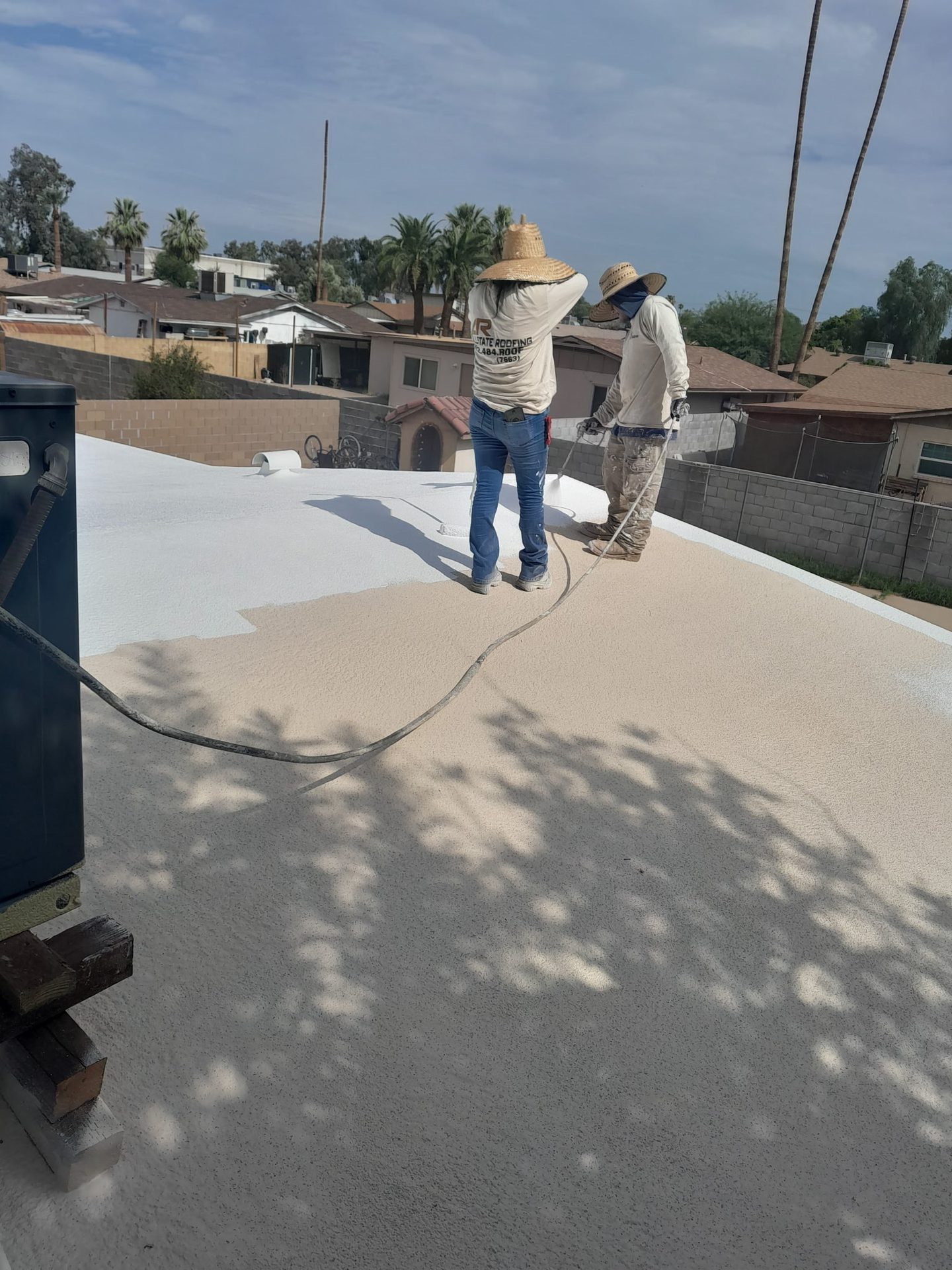 Allstate Roofing crew coating a low slope roof in the Phoenix area