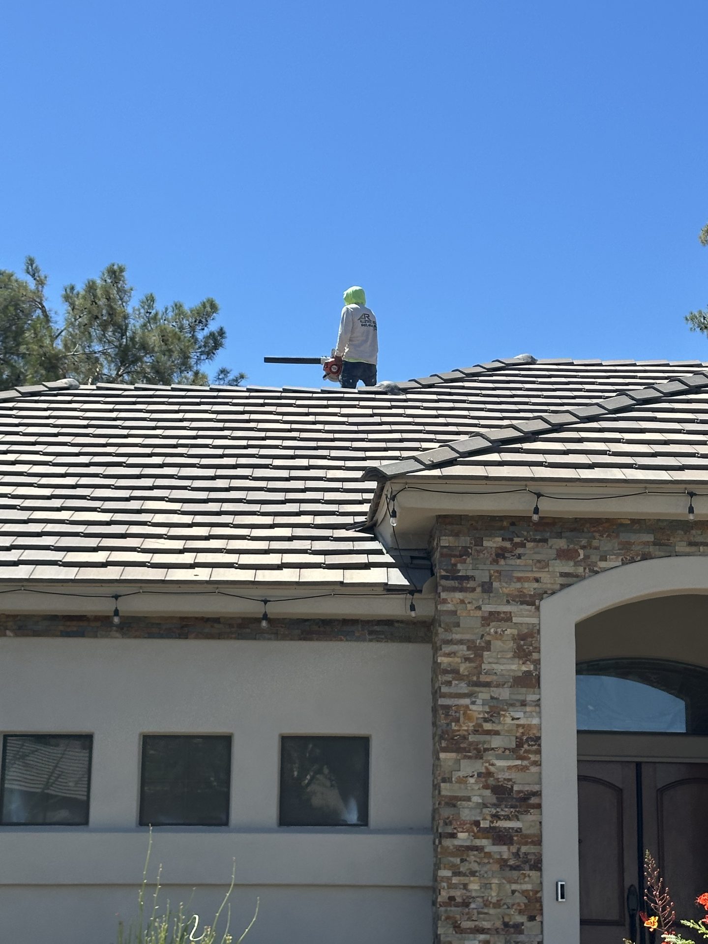 Allstate Roofing crew member working on a tile roof